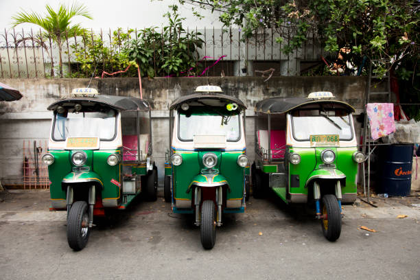 bangkok, thailand; 1st january 2023: three tuk tuks in a row on a city street. - jinrikisha thailand tuk transportation imagens e fotografias de stock