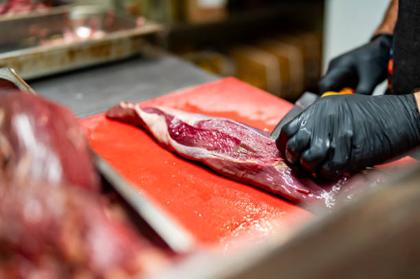 istock Chef Butcher cutting beef meat with knife on kitchen 1684308525