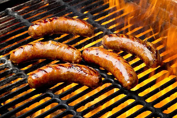 Photo of Bratwurst or Hot Dogs on Grill with Flames
