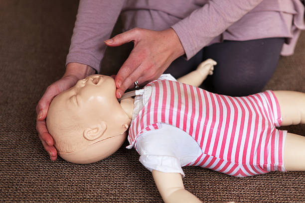 istock CPR training with baby doll laying on floor 168434794
