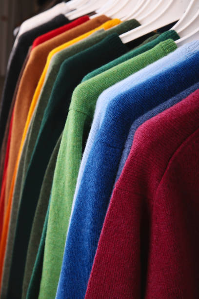 istock Warm sweaters. Autumn, winter clothes. Metal rack with various sweaters on hangers placed in modern fashion boutique 1684353220