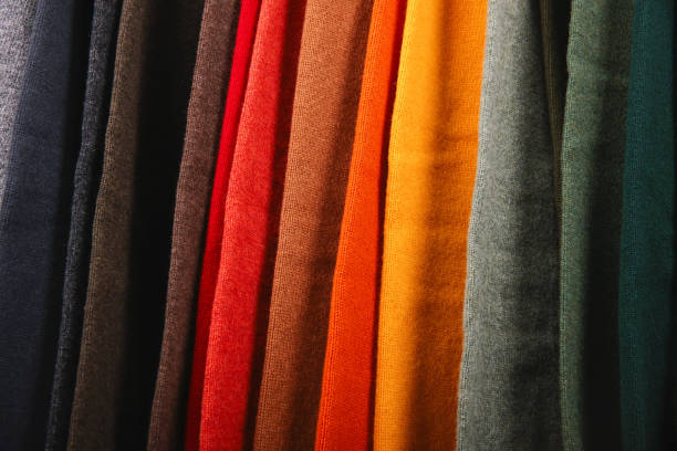 istock Warm sweaters. Autumn, winter clothes. Metal rack with various sweaters on hangers placed in modern fashion boutique 1684353225