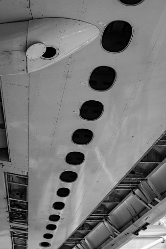 Close up of an airplane wing from below. Repairing in hangar.