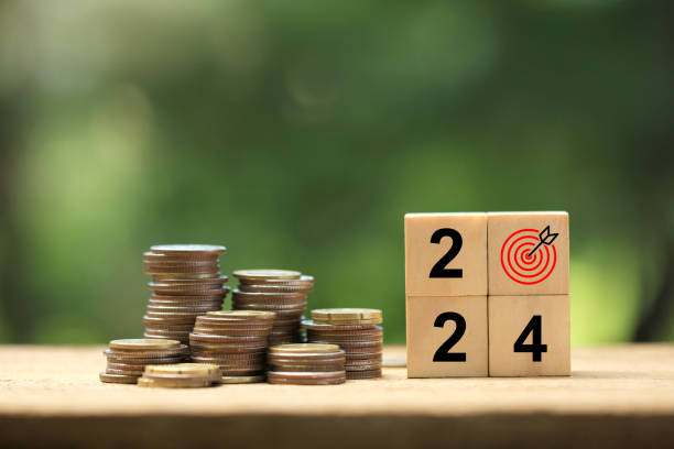 istock 2024 New Year goal plan action. Wooden cubes with 2024 and target icon with coins stack on a green background. Business plan and development for achieving goals. Goal achievement and success in 2024. 1684354125