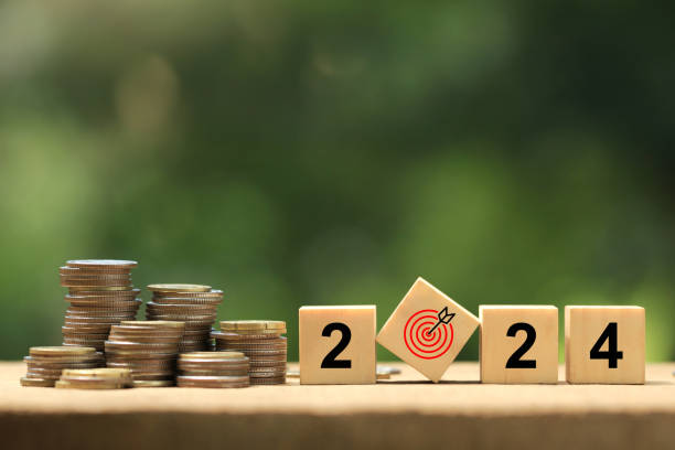 istock 2024 New Year goal plan action. Wooden cubes with 2024 and target icon with coins stack on a green background. Business plan and development for achieving goals. Goal achievement and success in 2024. 1684354126