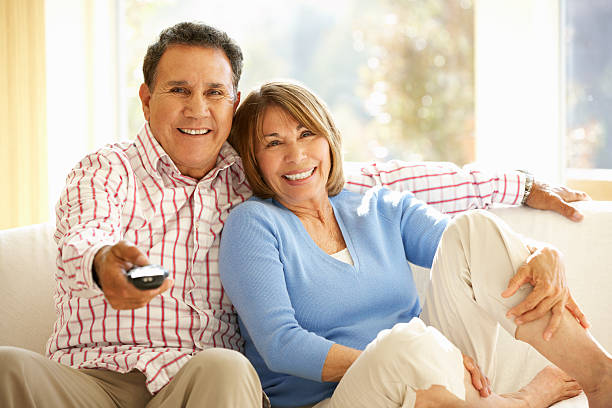 istock Senior Hispanic Couple Watching TV At Home 168436095