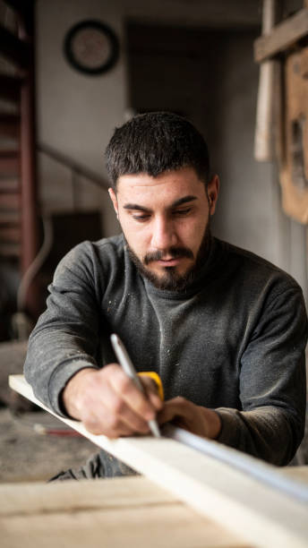 istock carpenter man measuring wood in workshop 1684363220