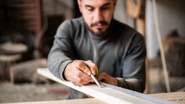 istock carpenter man measuring wood in workshop 1684363231