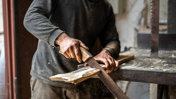 istock Close-up carpenter man is cutting wood with a saw 1684363743
