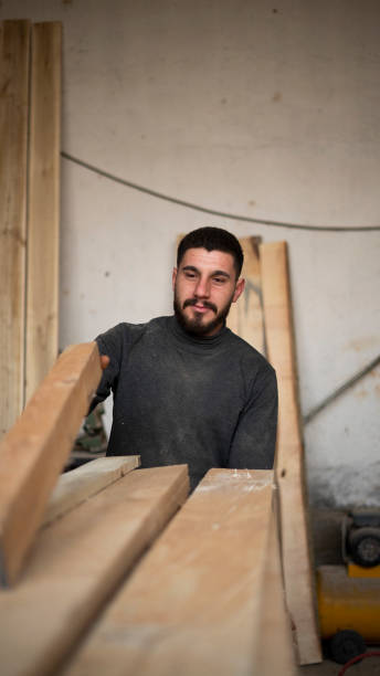 istock Carpenter man carrying wooden timbers 1684363768