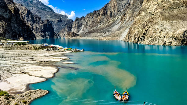 Boats in the beautiful Attabad Lake in the karakoram mountains Situated in Gojal Valley, Hunza, Gilgit Baltistan, Attabad Lake has a length of 14 kilometers and was created as a result of a natural disaster in the village of Attabad. This lake is known for its icy blue water, which originates from the Hunza River and the glaciers in the surrounding area karakoram highway stock pictures, royalty-free photos & images
