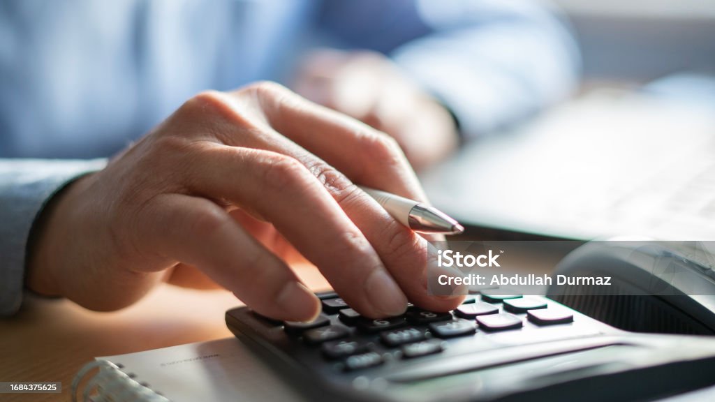 Close-up Businessman using calculator in office Expense Stock Photo