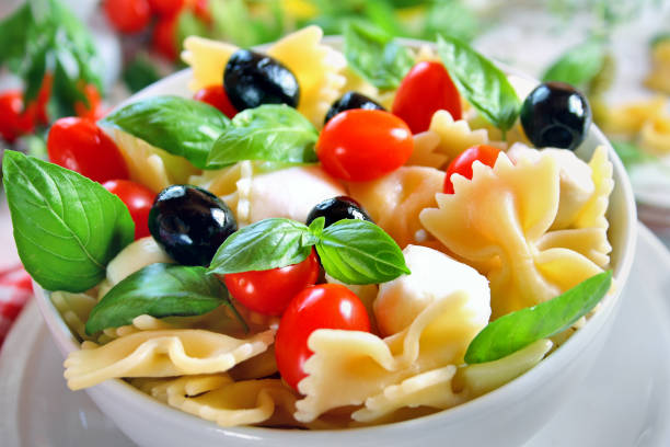 Bow tie pasta salad with mozzarella, black olives and cherry tomatoes