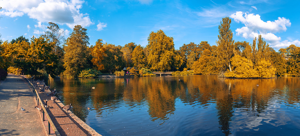 Panoramic view of Kelsey public park with foliage trees reflected in the lake in the fall season - Beckenham village, London