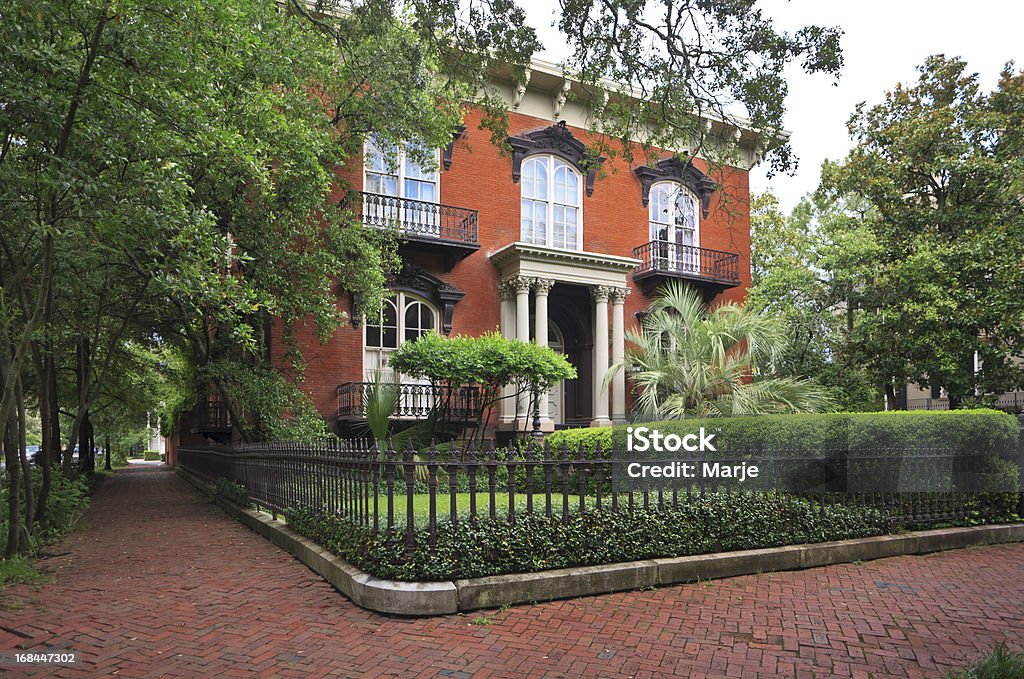 Historic Home: Savannah, Georgia Historic home in Savannah Georgia. Brick sidewalk, brick walls, columns, balconies, palm trees, lush landscaping. This is the elegant Mercer Williams House on Monterey Square in the Historic District of Savannah, Georgia. Georgia - US State Stock Photo