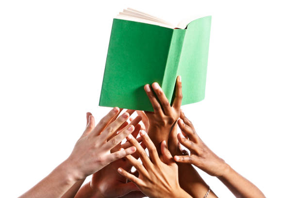 Many mixed hands reach for green-covered book against white