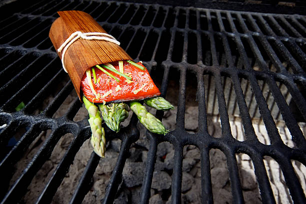 Wild Salmon fillet outdoor cedar wrap bbq grill Wild Salmon fillet cedar plank wrap outdoor bbq grill sockeye salmon filet stock pictures, royalty-free photos & images