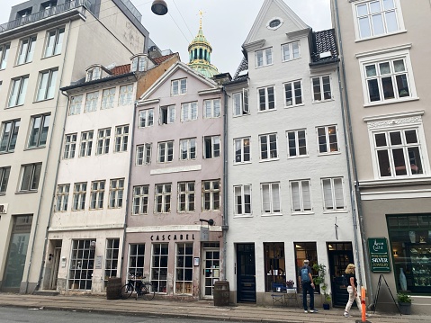 The photo was taken at Store Kongensgade, Copenhagen, Denmark on September 11th 2023. Behind the historic residential buildings can the tower of the Marble Church be seen. Frederik's Church, popularly known as The Marble Church for its rococo architecture, is an Evangelical Lutheran church in Copenhagen, Denmark.
