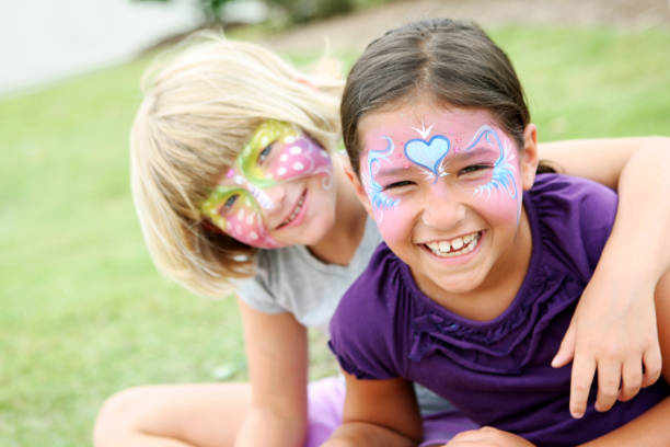 Happy kids with painted faces wearing purple