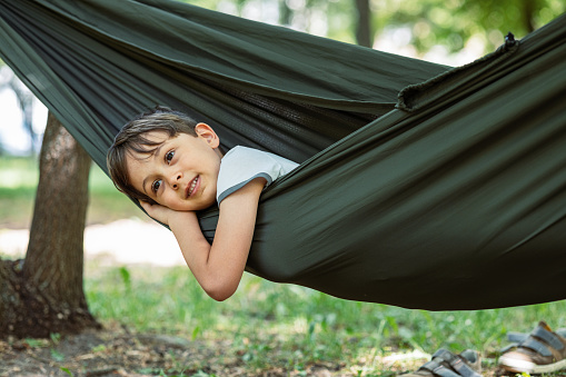 Photo of a little boy and his father having a relaxing moment in a hammock