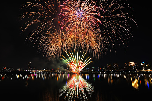 Colorful fireworks of various colors over night sky with    reflection in water