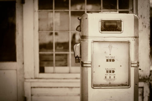 An old gas station fuel pump. Shallow depth of field. Sepia toned image, vintage processing.