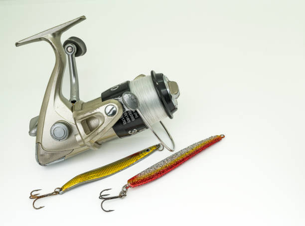 istock fishing wheel with two golden lures isolated on white 1684573447