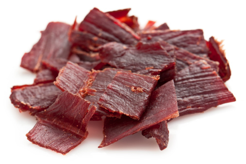 A closeup of beef jerky pieces on blue surface