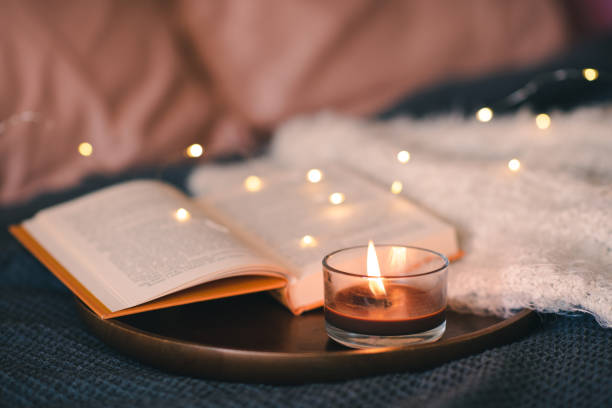istock Burning candle with book in bed 1684654604
