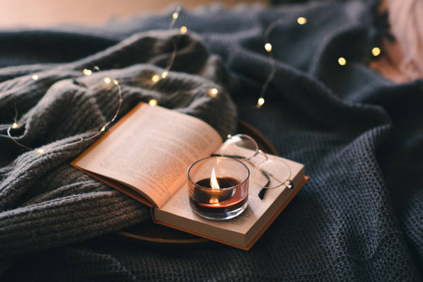 istock Burning candle with book in bed 1684654662