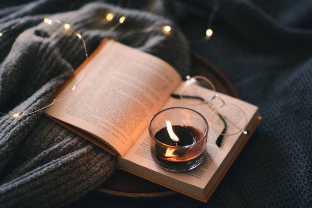 istock Burning candle with book in bed 1684654670