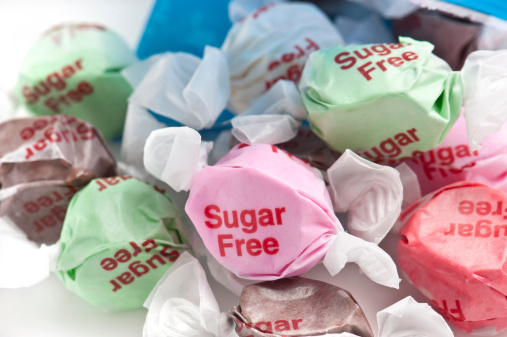 Sugar free Candies coming out of the bag on white background