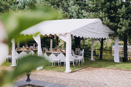 A summer tent with tables, food  and chairs on the wedding day