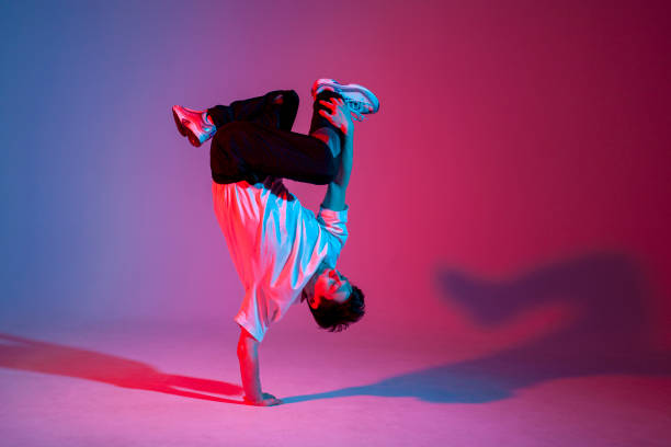 istock dancer doing acrobatic trick and dancing breakdance in neon red and blue lighting 1684671552