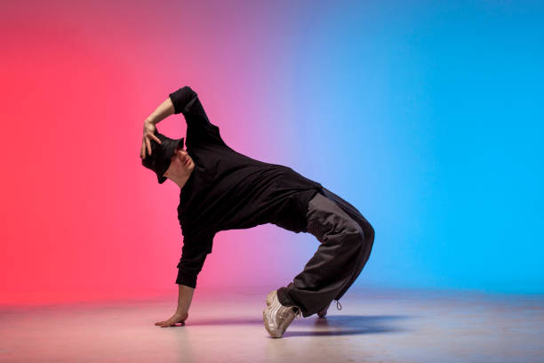 istock dancer doing acrobatic trick and dancing breakdance in neon red and blue lighting 1684671978
