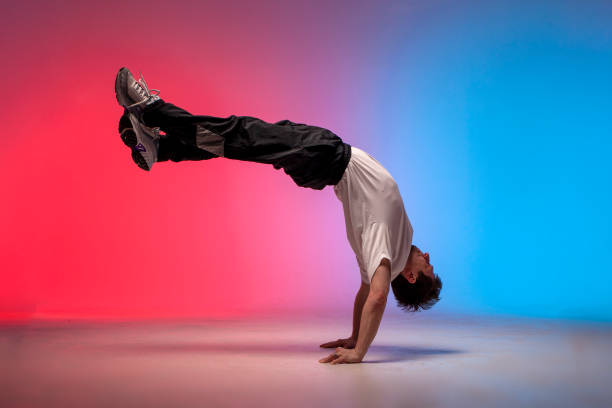 istock dancer doing acrobatic trick and dancing breakdance in neon red and blue lighting 1684672000