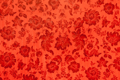 A detail of an antique velvet wall. Red flower texture. Detail of an antique baroque pattern in italian theater in Reggio Emilia first opening the April 21, 1857.