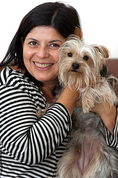 Smiling hispanic woman holding her dog