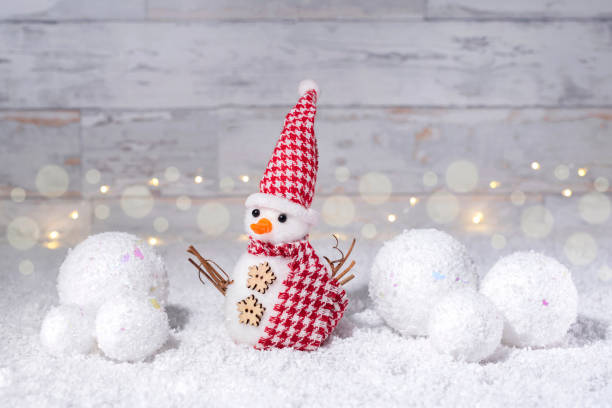 istock A snowman and a snowball on a white bokeh background. 1684710618