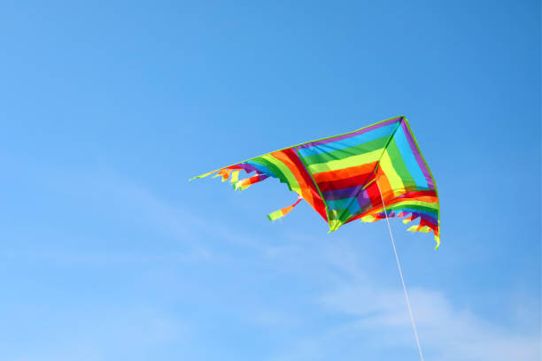 istock multicolored kite with long colorful tail flying free in blue sky 1684711862