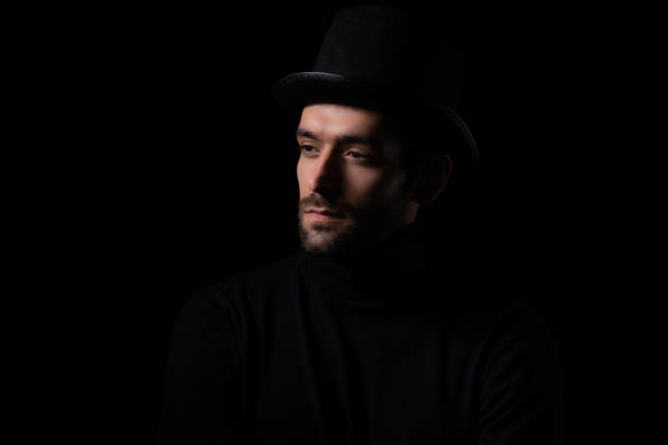 istock Pensive thinking handsome young beared man portrait Attractive bearded confident guy wear hat looking at blank space Smart man thinking in the dark room Cool man is good looking guy and smart guy 1684712602