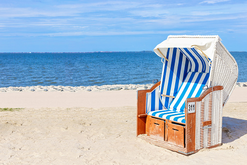 Nice stone beach and turquiose water of cote dAzur at summer morning with open traditional umbrellas, french riviera coast