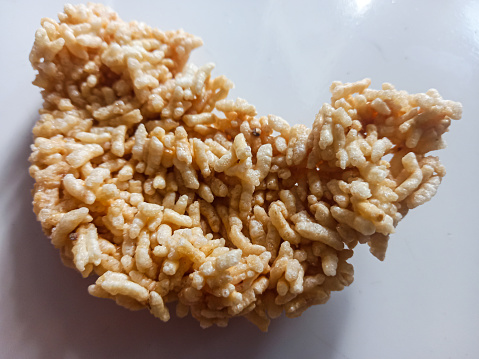 Rengginang is a type of thick cracker made from sticky rice which is shaped into rounds and dried by drying it in the sun, then frying it hot in cooking oil.