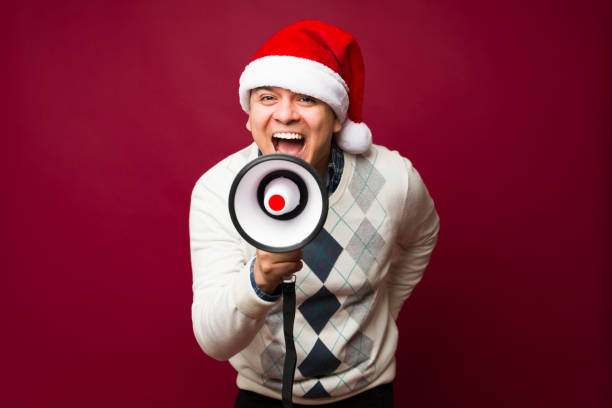 istock Hispanic man excited for christmas screaming with a megaphone 1684740395