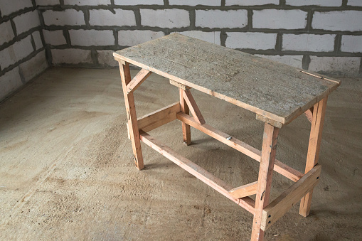 wooden trestles inside the cottage. in the background is a wall of aerated concrete blocks. this material is also known as foam concrete gas. The concept of repair and construction