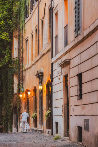 An elderly Italian man returns home with his shopping on a quiet backstreet in the historic Rione VI Parione district of central Rome.