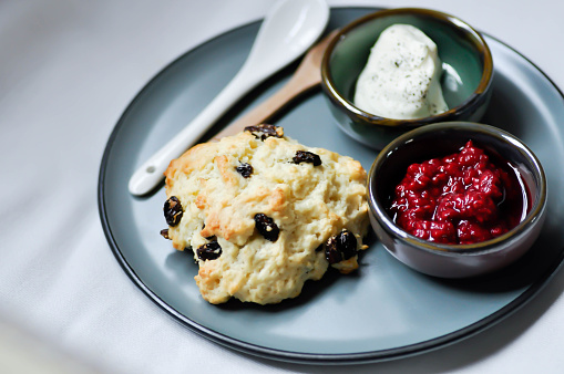 scone with berry sauce or berry dressing and whipping cream