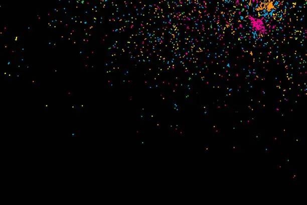 Vector illustration of Colorful explosion of confetti. Colored glitter and sprinkles. Grainy abstract holiday illustration. Isolated on black background. Multi colored texture. Vector.