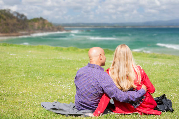 istock Couple Sitting on Grass Looking to Sea 168482887