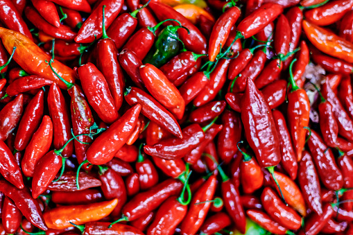 Macro closeup of red chili peppers piled high in a Colombian market